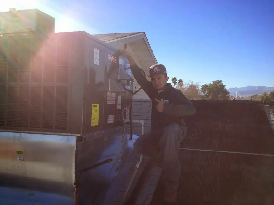 HVAC technician performing Heat Pump Repair on a rooftop unit in Tacoma